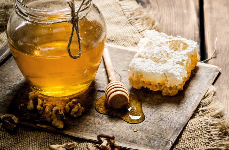 A honeycomb and a jar of honey