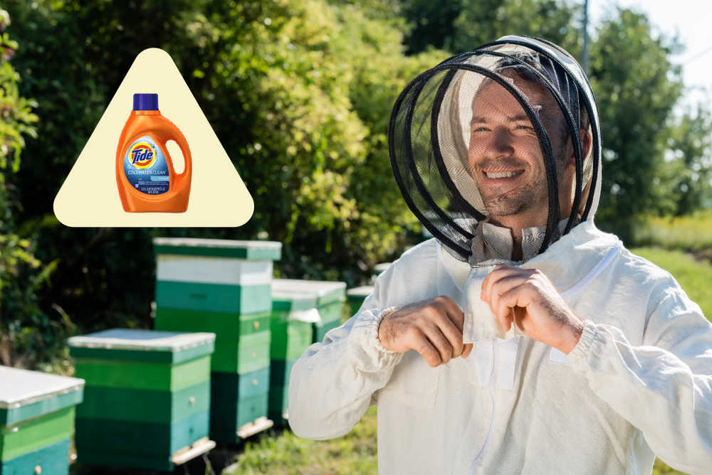 A beekeeper wearing a bee suit next to some hives