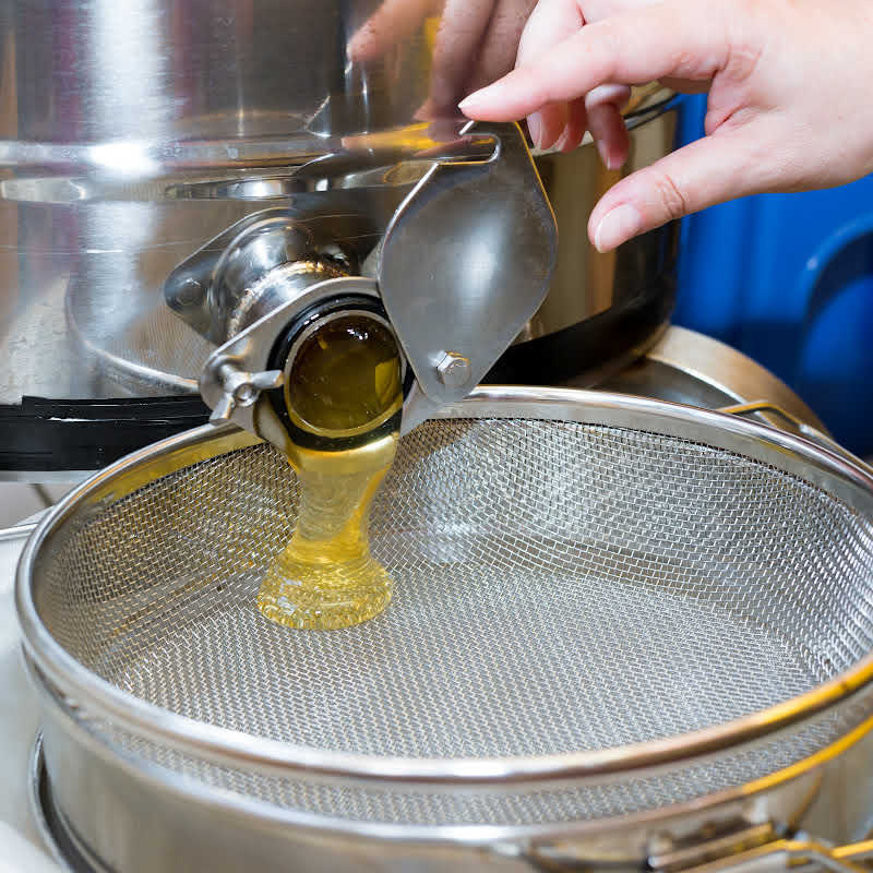 Liquid honey flowing from the honey gate after extraction
